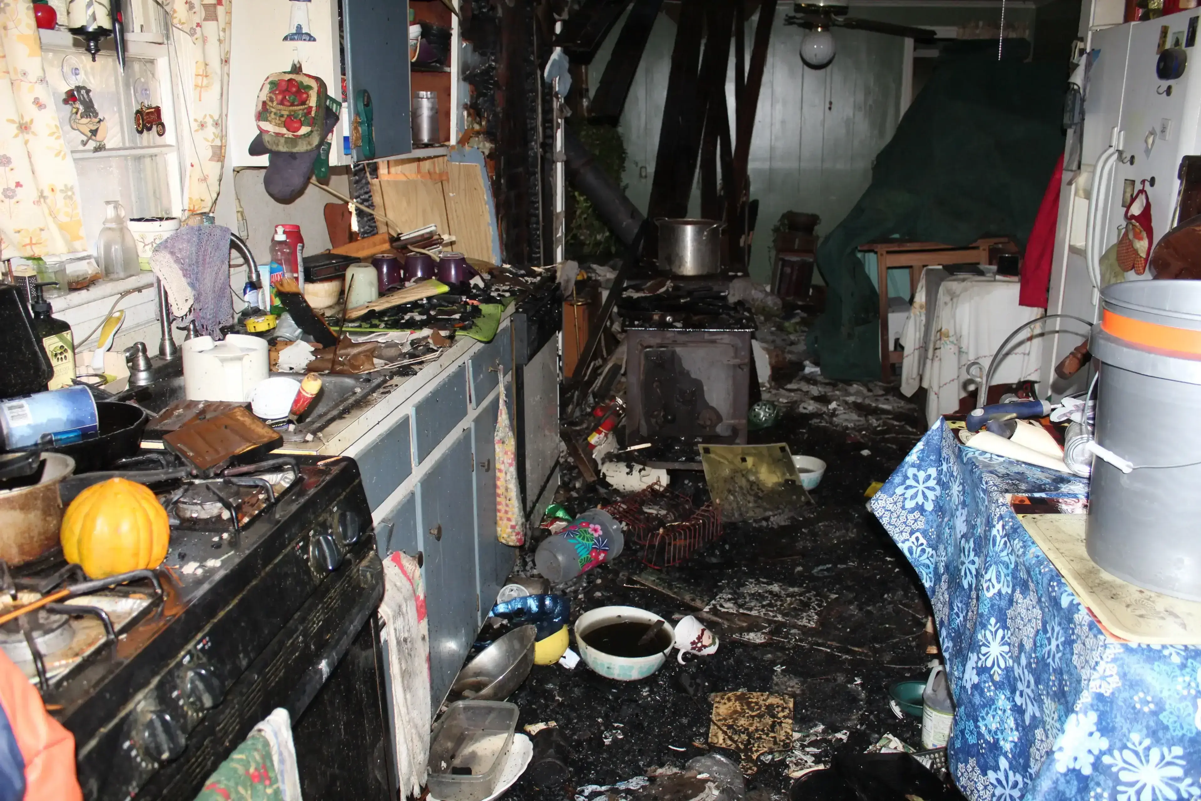 677da2ef21661_2-scaled (1) (1) A kitchen with many items and debris on the floor.