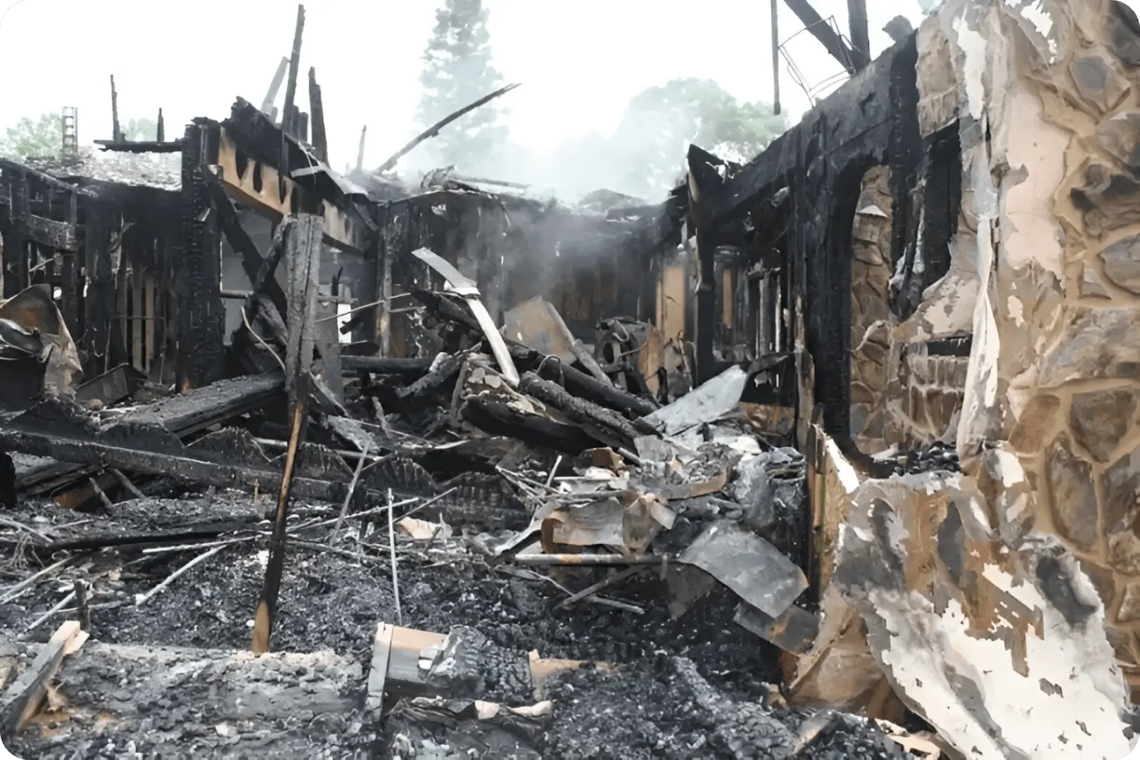 hero (1) Here's an alt tag for the image: Burned-out house, fire damage, debris.
